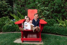 Smiling Young Kids with Baby Brother in Big Red Chair in Home by San Francisco Family Photographer